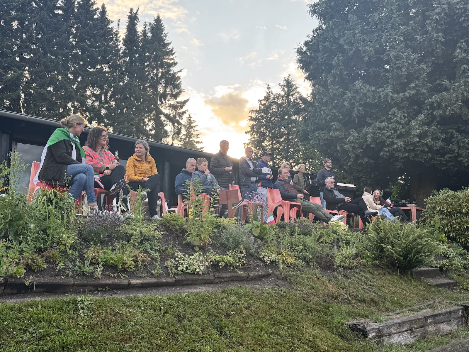 Menschen im Grünen schauen auf einen Tennisplatz