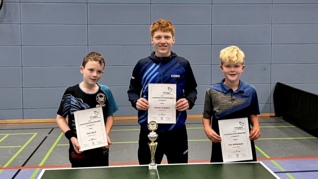 Drei Jungs mit Urkunden vor einer Tischtennisplatte