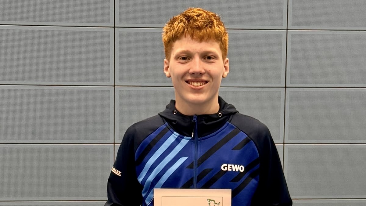 Junger Mann im Trainingsanzug hält eine Urkunde in der Hand. Sein Name ist Hannes Schubert