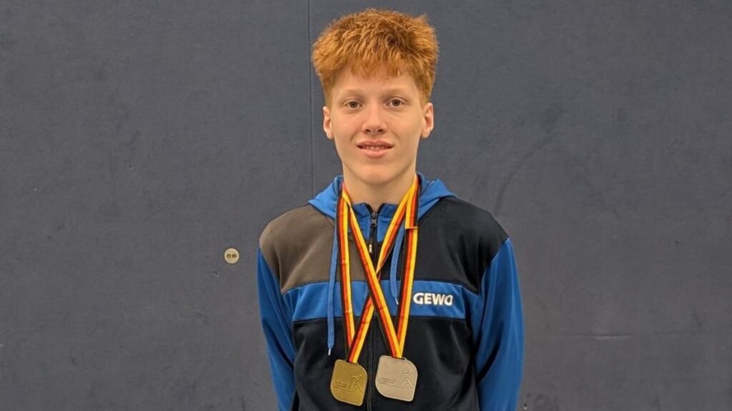 Junger Sportler mit zwei Medaillen