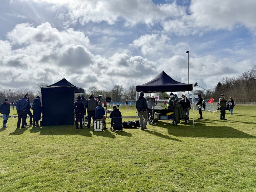 Pavillons und ein Kamerateam auf einem Fußballplatz