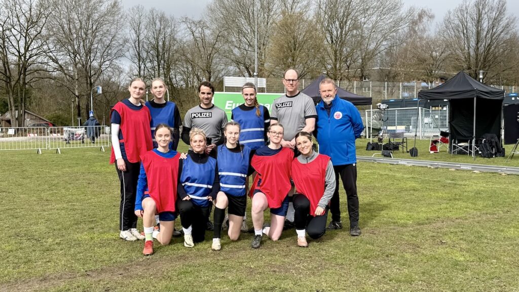 Fußballspielerinen und Spieler auf einem Fußballplatz