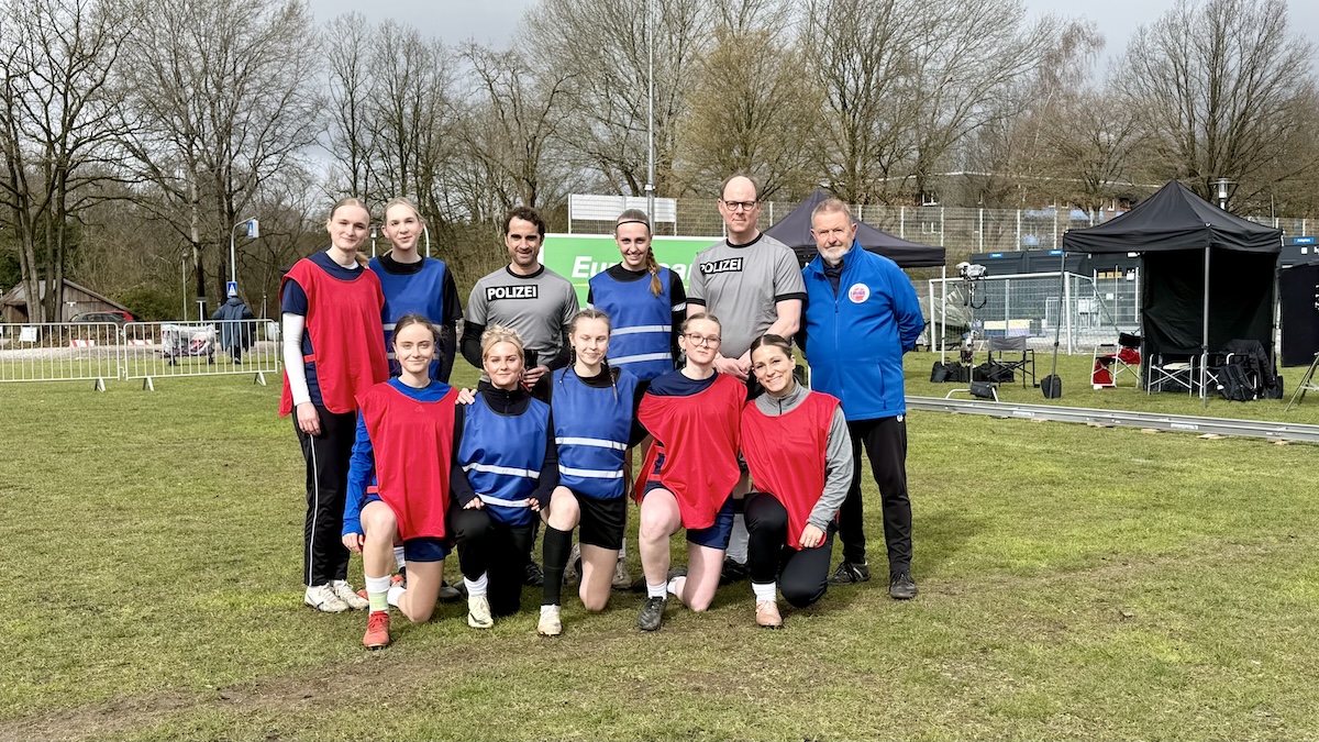 Fußballspielerinen und Spieler auf einem Fußballplatz