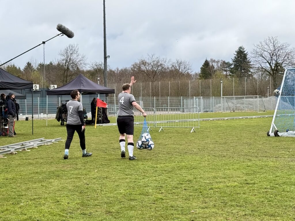 Zwei Männer in Fußball-Kleidung laufen auf den Platz