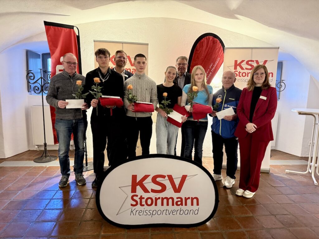 Eine Gruppe von Sportlerinnen und Sportlern mit Preisen in der Hand